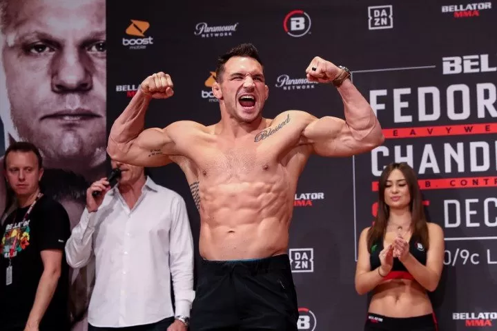 Michael Chandler flexes on the scale at the Bellator 237 weigh-ins in Japan