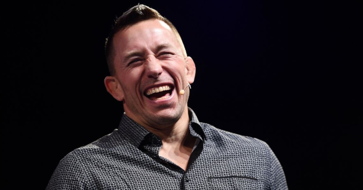 Georges St-Pierre laughs during an interview on stage