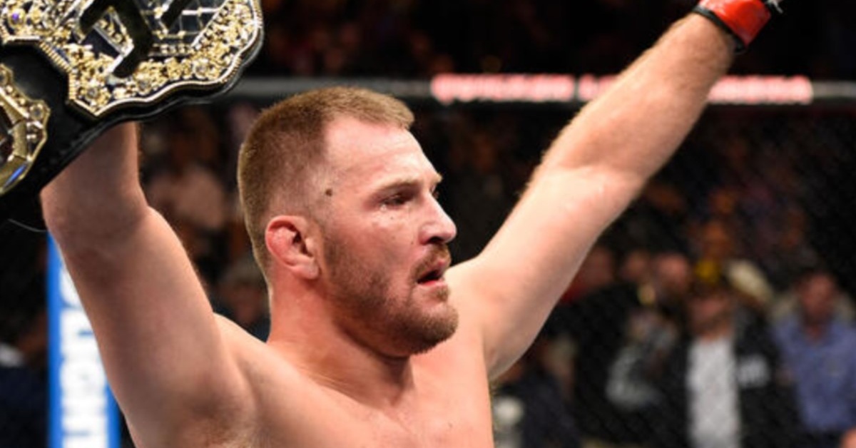 Stipe Miocic raises both arms in the Octagon with the UFC heavyweight belt in hand
