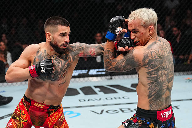 Ilia Topuria with his hand raised after knocking out Charles Oliveira at UFC 317