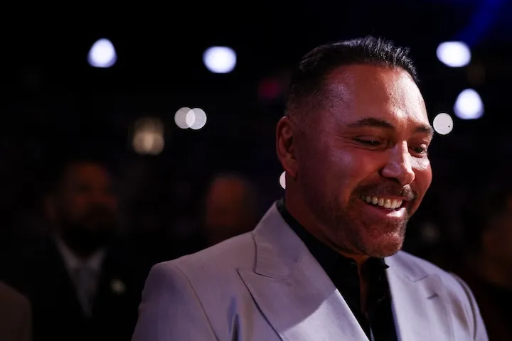 Oscar De La Hoya smiles ringside in a light suit at T-Mobile Arena