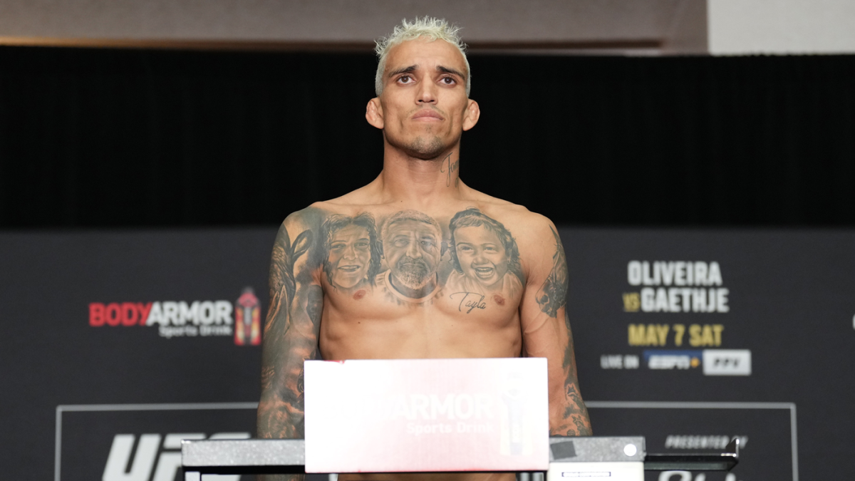 Charles Oliveira on the scale at the UFC 274 weigh-ins, where he came in half a pound over the lightweight limit
